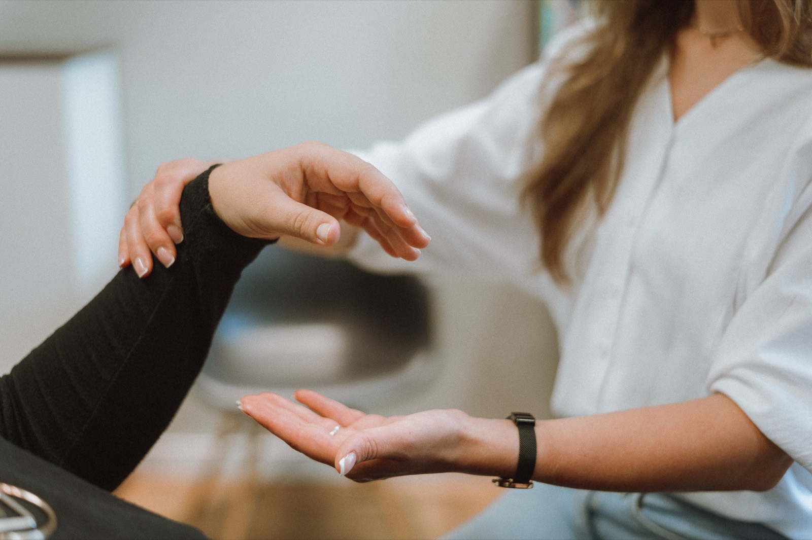 Stefanie Fronert hält behutsam die Hand einer Klientin während einer Sitzung