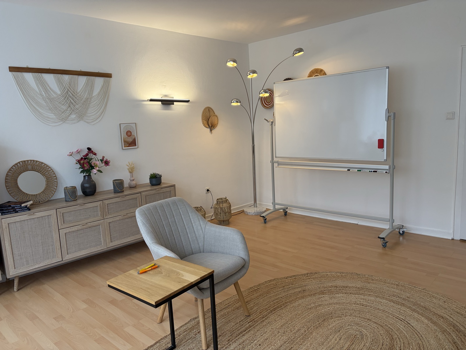 Praxisraum mit Whiteboard, Bogenlampe und gemütlicher Sitzgelegenheit